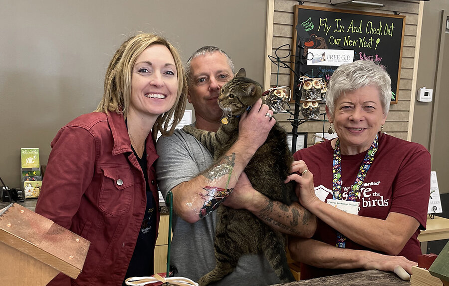 Trish and Brandon Lohman, with Sales Associate Anne McDaniel with the store mascot Newt the cat