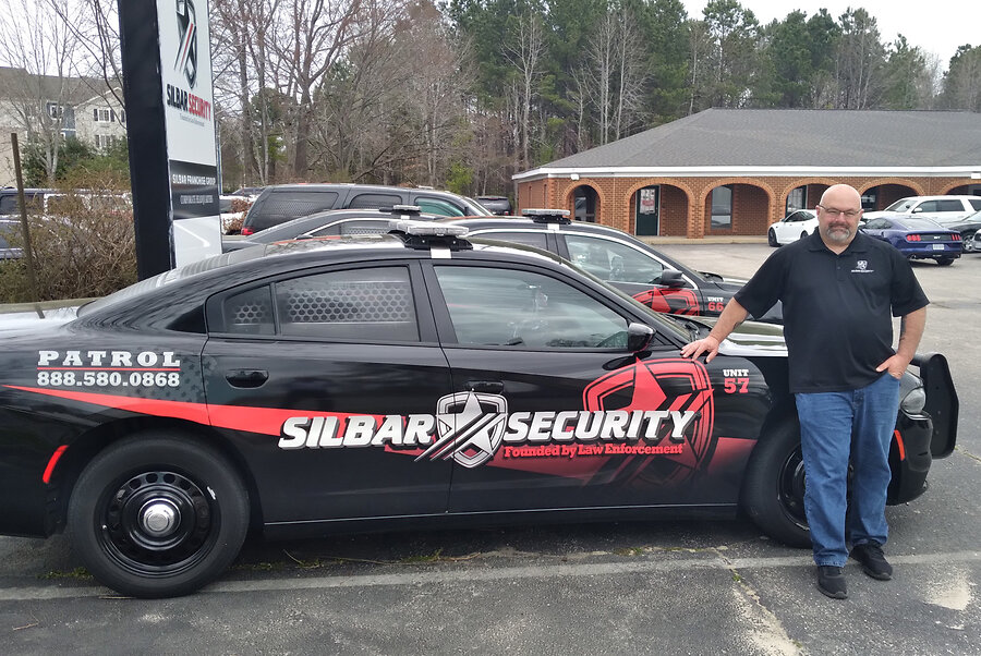 Brandon Dean, CEO of Silbar Security, with one of many patrol cars on premise